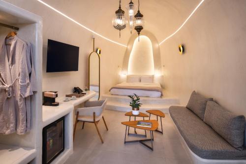 a living room with a couch and a bed at Athina Luxury Suites in Fira