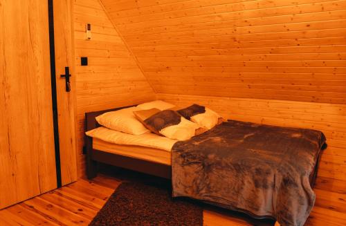 a small bed in a wooden room at Gwiazda Północy Gołdap Dom na Wynajem in Gołdap