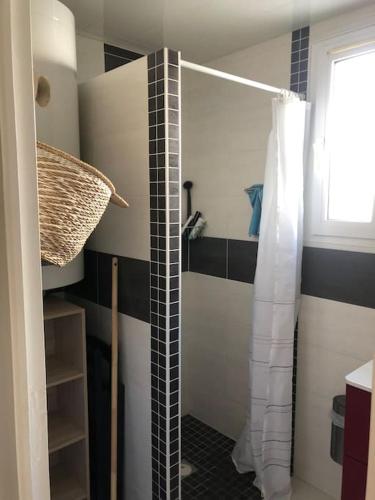 La salle de bains est pourvue d'une douche et de carrelage noir et blanc. dans l'établissement Maison de vacances avec piscine , dans résidence, à Meschers-sur-Gironde