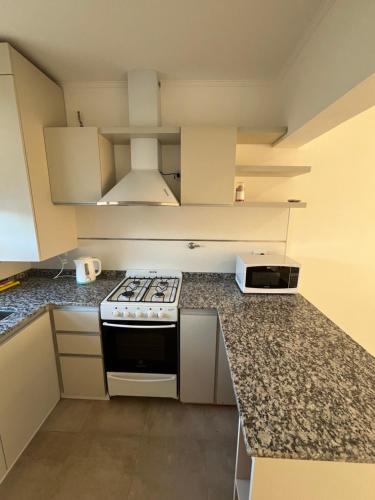 a kitchen with a stove and a counter top at TERRA - Departamento 2 in Esperanza