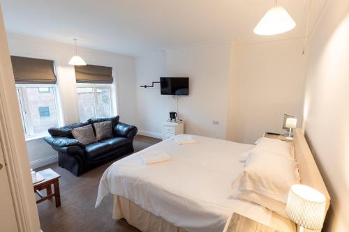 Un dormitorio con una cama grande y un sofá. en Prospect House, en Whitby