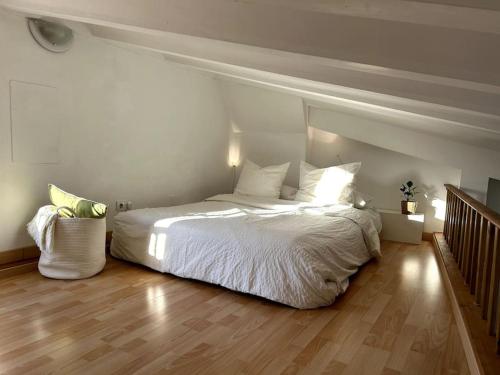 a bedroom with a white bed and a wooden floor at La Roca Valencia in Valencia