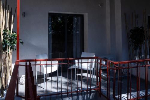 a balcony with white chairs in a room at La Scogliera In in Aci Castello