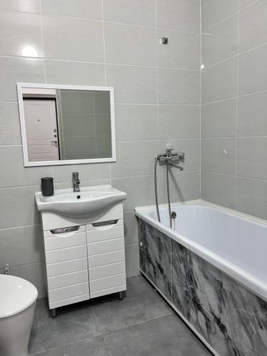 a bathroom with a sink and a tub and a toilet at Евродвушка in Kokshetau