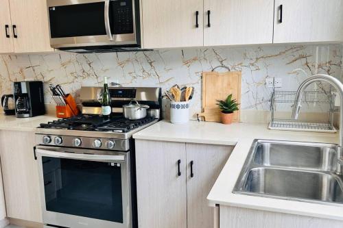 a kitchen with a stainless steel stove and a sink at Mid-Century Modern Charm in Discovery Bay