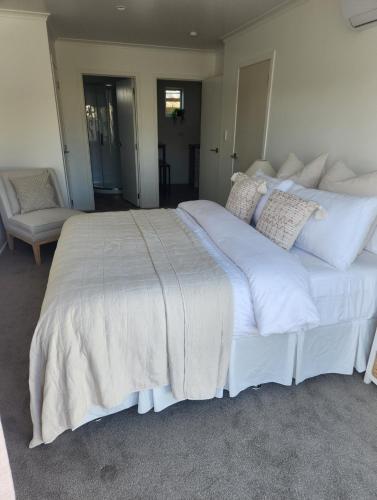 a large white bed with white sheets and pillows at Guest House on Guthrie in Havelock North