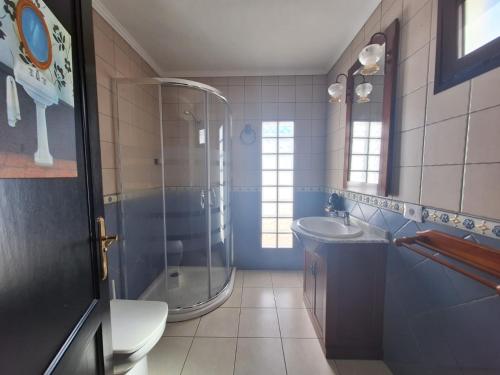 uma casa de banho com um chuveiro, um lavatório e um WC. em Casa Paraiso em San Bartolomé