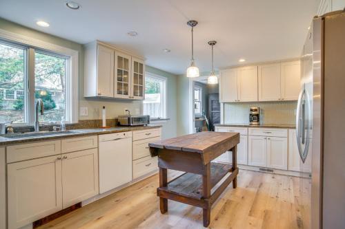 a kitchen with white cabinets and a wooden table at 1 Mi to Beach Cape Cod Family Home in Bourne! in Bourne