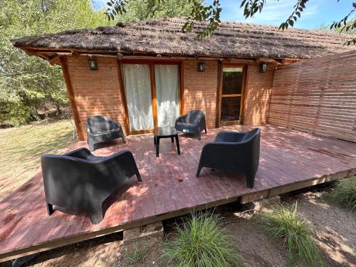een groep stoelen op een houten terras bij Casa Playa Mansa in Mina Clavero