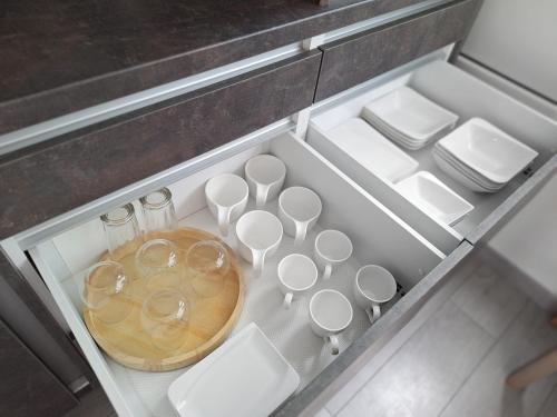 a drawer with cups and wine glasses in it at APARTMENT NEVERA in Rijeka