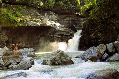 a person standing in front of a waterfall at Suchipakari Amazon Eco -Lodge & Jungle Reserve in Puerto Misahuallí