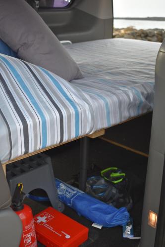 a bed in the back of a van at FurgoCamper Van H1 in Tetir