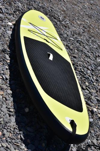 a yellow and black surfboard sitting on the rocks at FurgoCamper Van H1 in Tetir