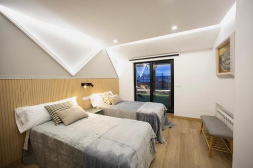 a room with two beds and a window at Lucus Skyline & Terrace by Lugo Collection in Lugo