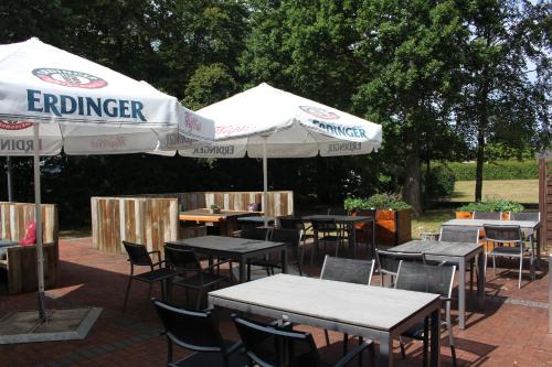 a group of tables and chairs with umbrellas at Gästehaus St. Martin in Ulmen