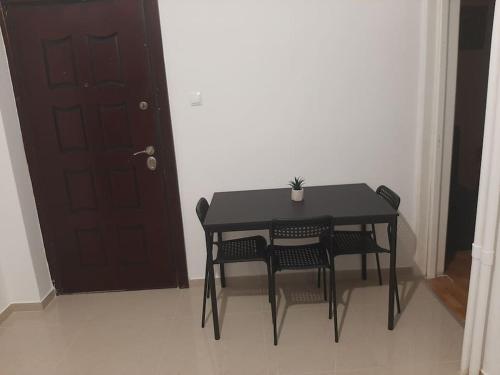 a black table and chairs in a room with a door at Modern apartmen in Athina in Athens