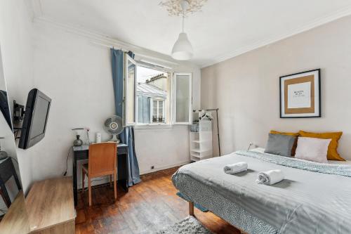 a bedroom with two beds and a desk and a window at Wonderful apartment close Champs-Elysées in Paris