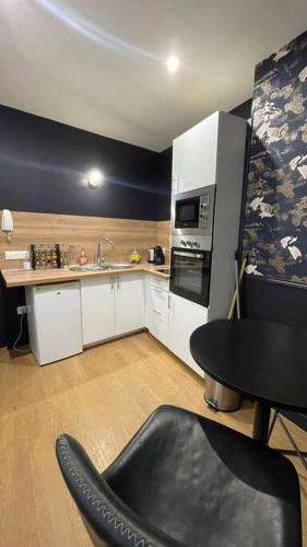 une cuisine avec une table, un évier et une cuisinière dans l'établissement 2 pièces au cœur d'Angers, à Angers