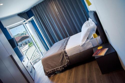 um quarto de hotel com uma cama e uma janela em NINARY APARTMENTS a due passi dal centro storico em Alba