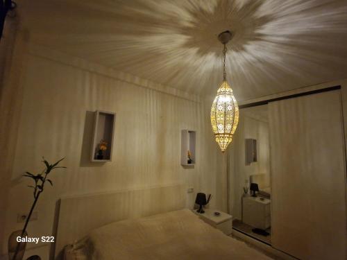 Un dormitorio con una cama y una lámpara de araña. en Marveo, en La Oliva