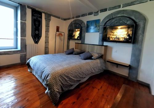 a bedroom with a bed with a fireplace and wooden floors at Suite privative Le seigneur des anneaux Gondor in Vertaizon