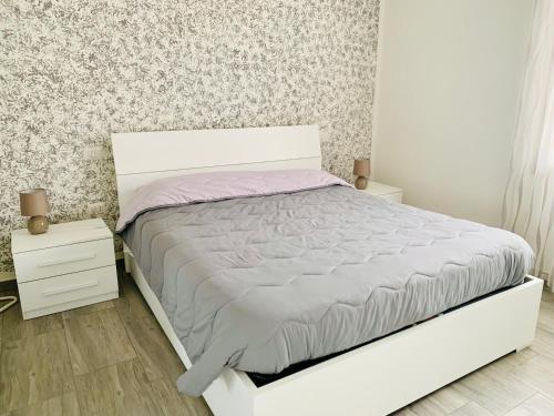 Serramanna的住宿－Luce，卧室配有白色的床和2个床头柜