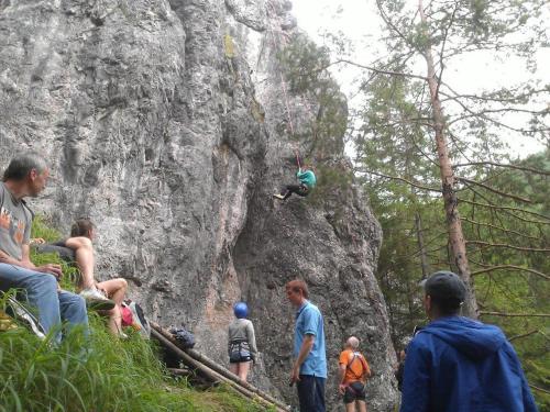 a group of people watching a person jumping off a rock at Drevenica JURsport Dúbrava in Dúbrava