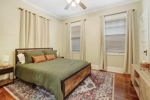 a bedroom with a bed in a room with windows at Large Groups Welcome - 2 Homes Next Door in New Iberia