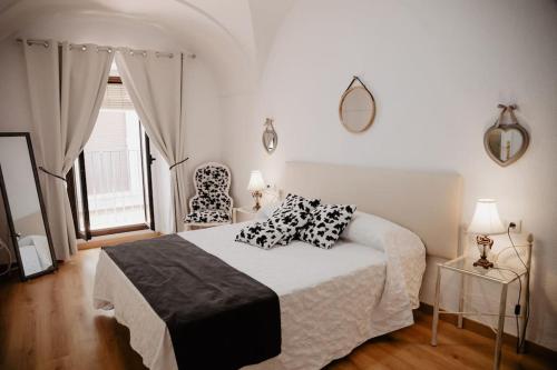 1 dormitorio con cama, ventana y silla en Flor de Lis 1, en Cáceres