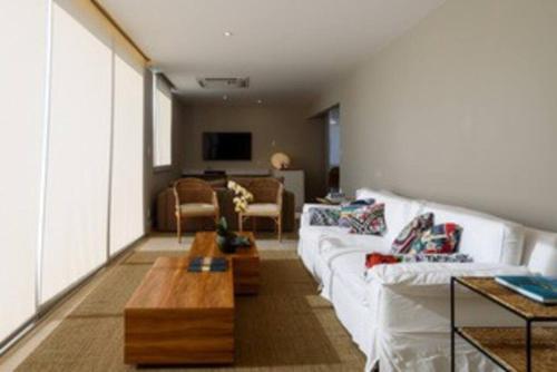 a living room with a white couch and a table at Cobertura Frente Lagoa vista excepcional Rio de Janeiro in Rio de Janeiro