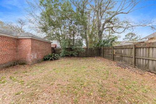 an empty yard with a fence and a tree at Large Groups Welcome - 2 Homes Next Door in New Iberia