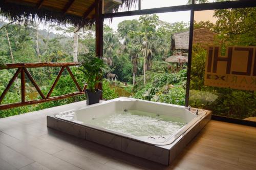 a bath tub in a room with a view of a forest at Suchipakari Amazon Eco -Lodge & Jungle Reserve in Puerto Misahuallí