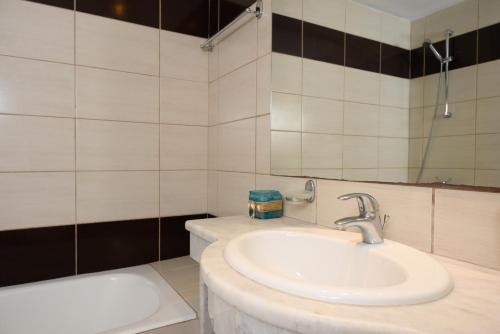 a bathroom with a sink and a tub at Havania Apartments in Agios Nikolaos