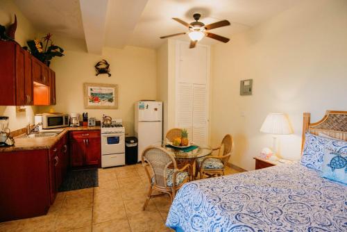 a bedroom with a bed and a kitchen with a table at Indigo in Cruz Bay