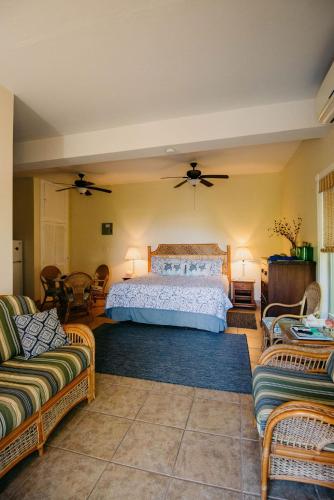 a bedroom with a bed and two chairs at Indigo in Cruz Bay