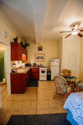 eine Küche mit roten Schränken, einem Tisch und einem Kühlschrank in der Unterkunft Indigo in Cruz Bay