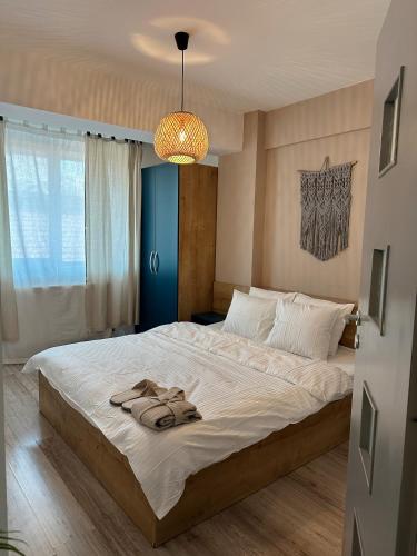 a bedroom with a large bed with a pair of slippers on it at Modern flat - apartament nou aproape de Spital și Aeroport in Iaşi