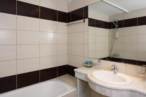 a bathroom with a sink and a bath tub at Havania Apartments in Agios Nikolaos