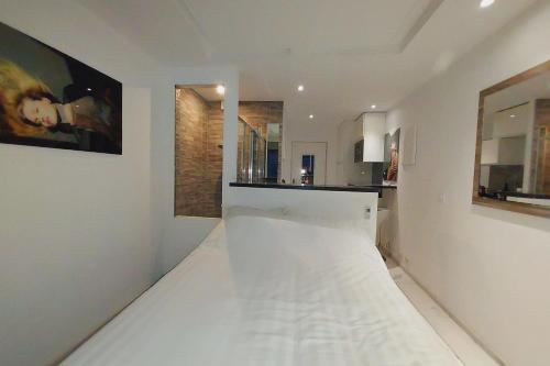 - une cuisine avec des murs blancs et un sol blanc dans l'établissement Naturiste Cap d'Agde Héliopolis F 72, au Cap d'Agde