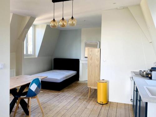 Habitación pequeña con cama y mesa. en Superbe Studio avec vue sur la mer à 180° en Villers-sur-Mer