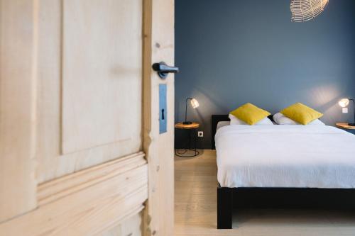 a bedroom with a bed with yellow pillows at Vakantieappartement Oosteroever Oostende in Ostend