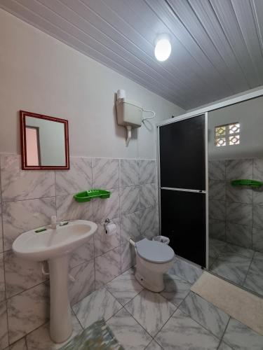 La salle de bains est pourvue d'un lavabo et de toilettes. dans l'établissement Recanto Aconchego Itapoá, à Itapoá