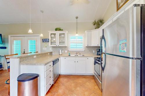 a kitchen with white cabinets and a refrigerator at Marquesas 401 in Padre Island