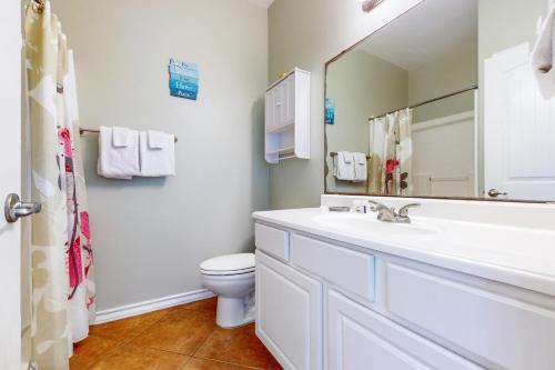 a bathroom with a sink and a toilet and a mirror at Marquesas 401 in Padre Island