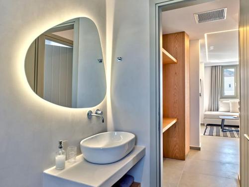 a bathroom with a white sink and a mirror at Sapphire apartment - Paros Gem in Naousa