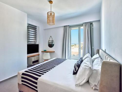 a bedroom with a large bed with a large window at Sapphire apartment - Paros Gem in Naousa