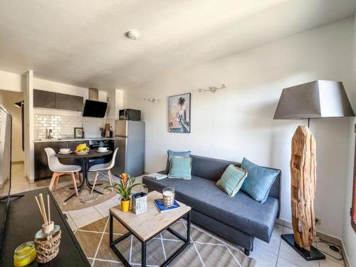 un salon avec un canapé bleu et une cuisine dans l'établissement Le Refuge Douillet, à Grisolles