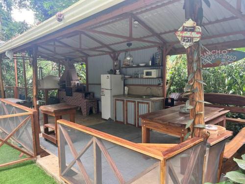 a pavilion with a kitchen and a table and benches at Comfy jungle place / FiberOptic/1 km from the beach in Cocles