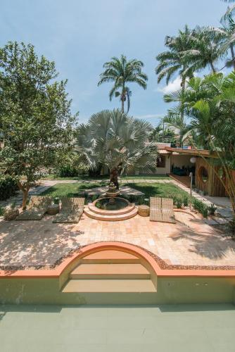 a courtyard with a fountain and palm trees at Pousada Pazuu in Ubatuba
