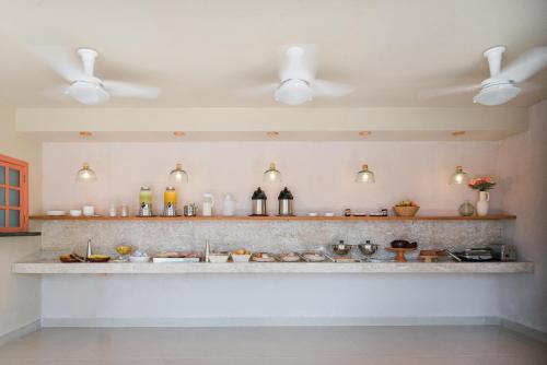 a kitchen with a sink and a counter with lights at Pousada Pazuu in Ubatuba